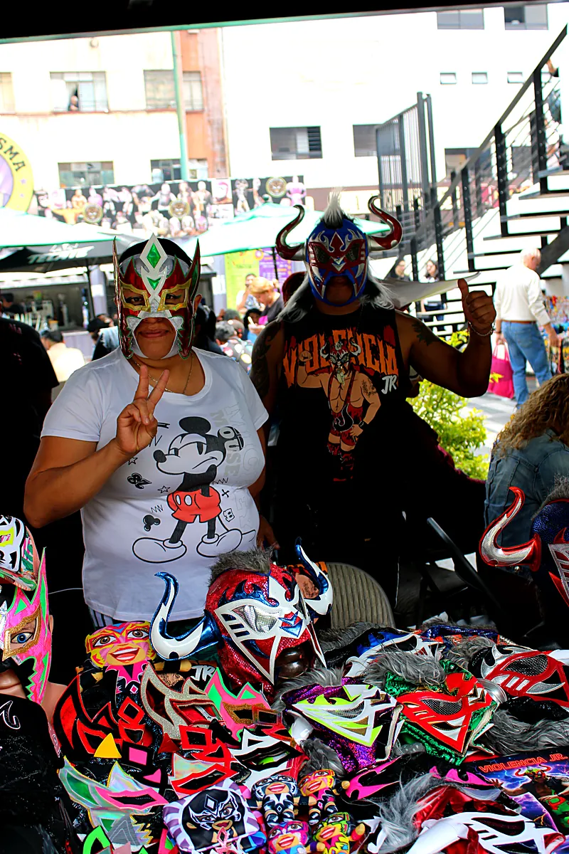 Fans posando con máscaras de luchadores en Expo Máscaras, eventos de lucha libre en CDMX