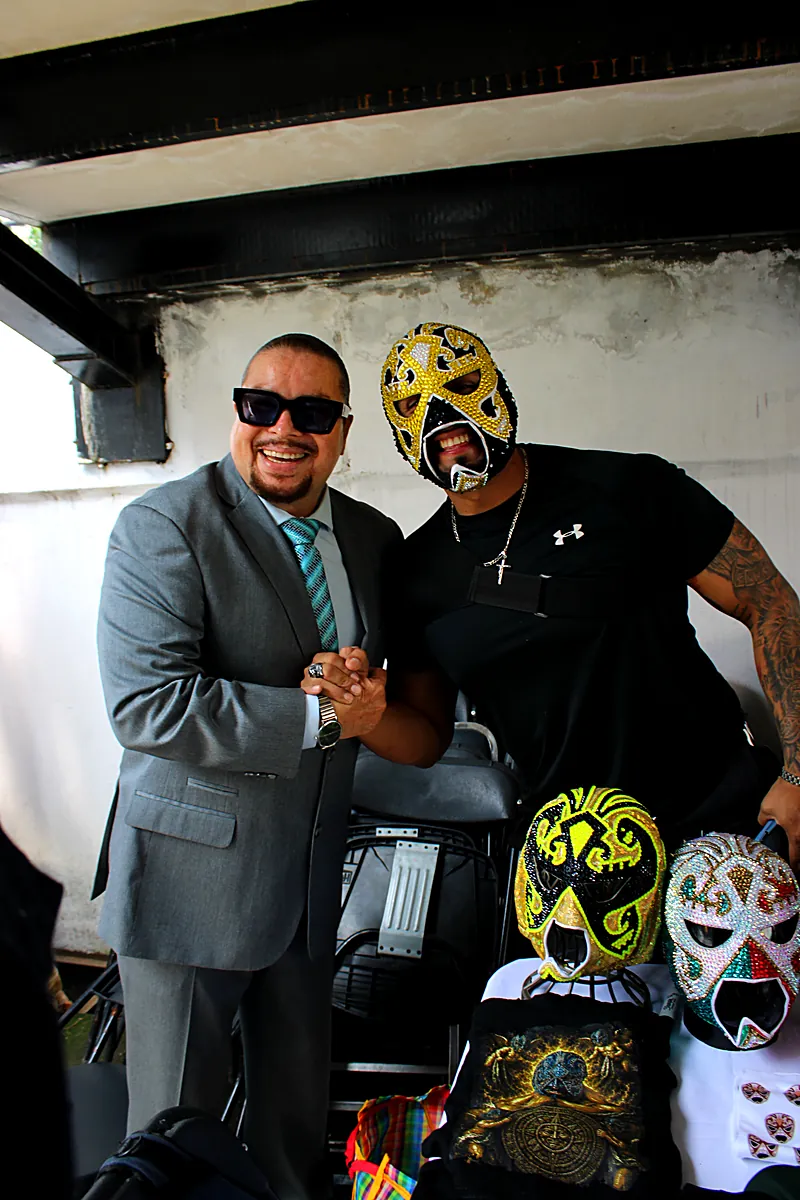 Saludo entre un luchador invitado y un asistente en Expo Máscaras 2026